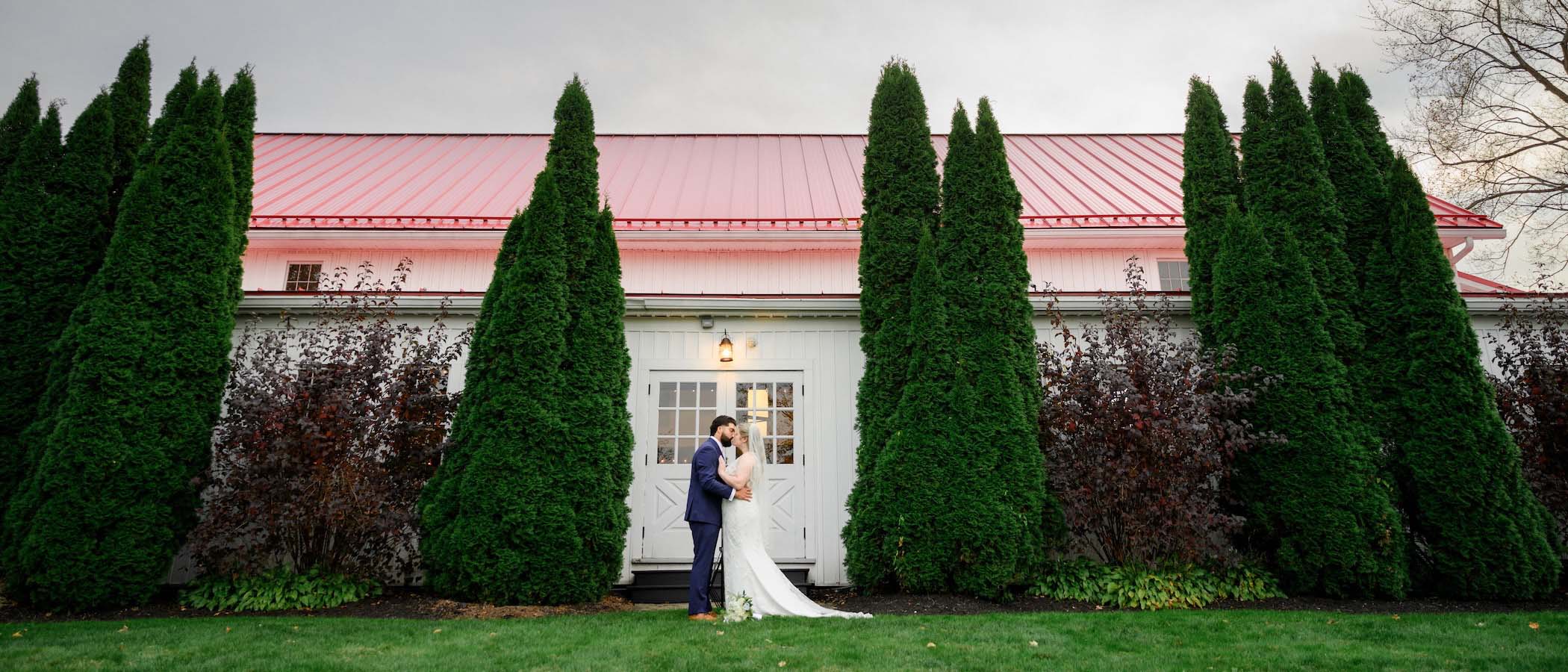 Historic white ballroom building with its signature red roof at dusk